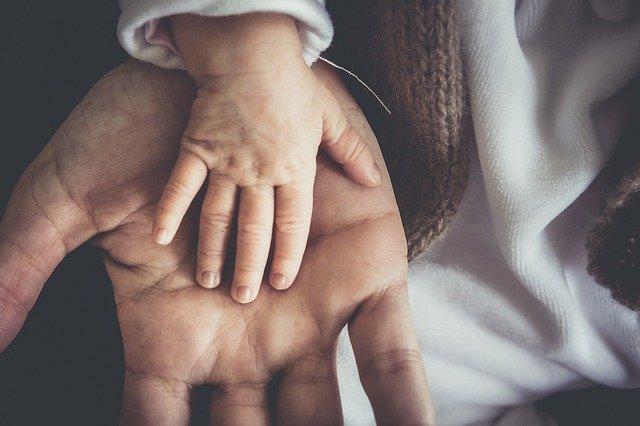 Die Hand des Babys auf der Hand des Vaters